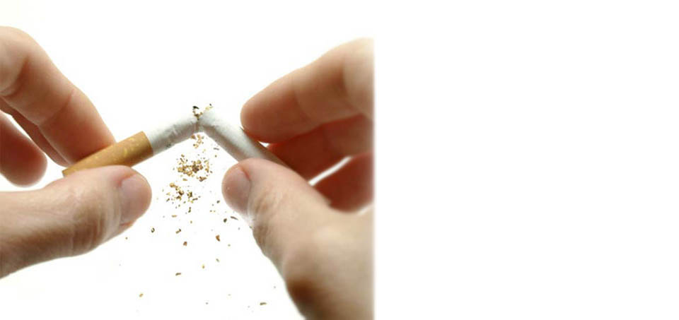 Manos que rompen en dos un cigarro, dejar de fumar